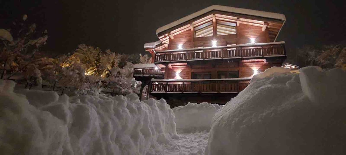Le chalet illuminé sous la neige